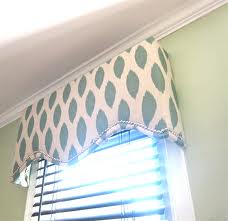 Upholstered cornice or valance with light color print fabric and horizontal wood blinds